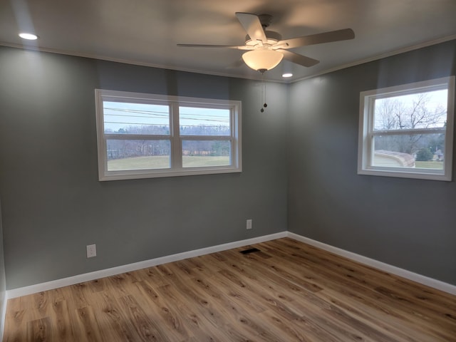 empty room with crown molding, wood-type flooring, a healthy amount of sunlight, and ceiling fan