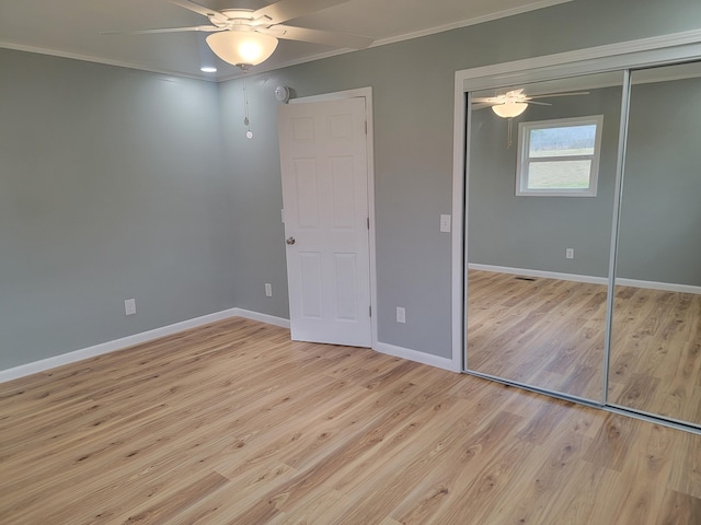 unfurnished bedroom featuring ceiling fan, ornamental molding, a closet, and light hardwood / wood-style flooring