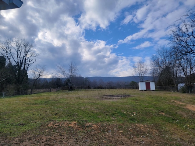 view of yard with a rural view, a mountain view, and a storage unit