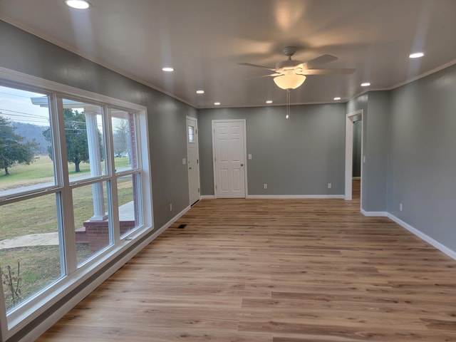 unfurnished room featuring crown molding, ceiling fan, and light hardwood / wood-style floors