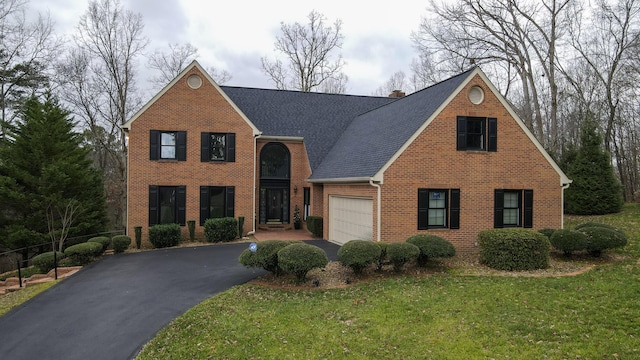 view of front of house with a front yard and a garage