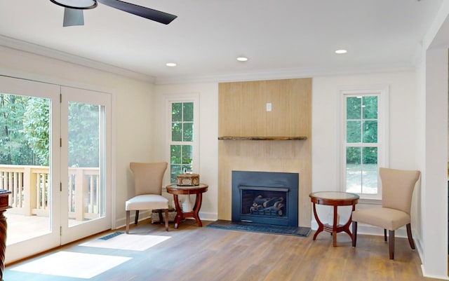 living area featuring ceiling fan, crown molding, and hardwood / wood-style flooring