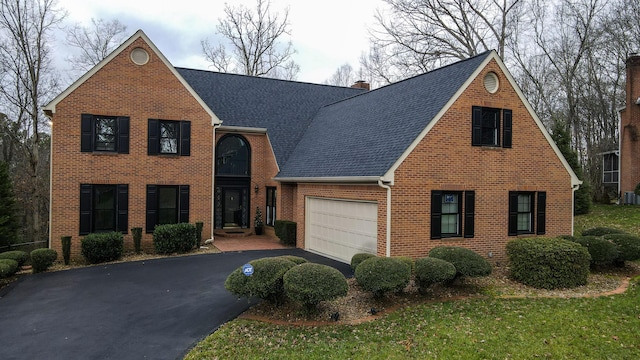 view of front of property featuring a garage, a front yard, and central AC