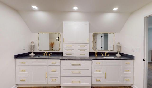 bathroom with vaulted ceiling, hardwood / wood-style floors, and vanity