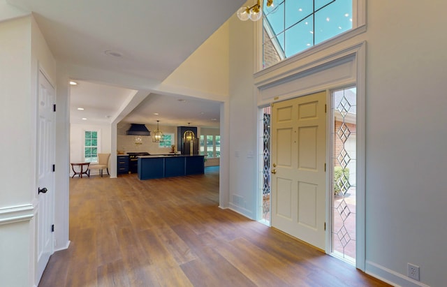 foyer with dark hardwood / wood-style floors and a chandelier