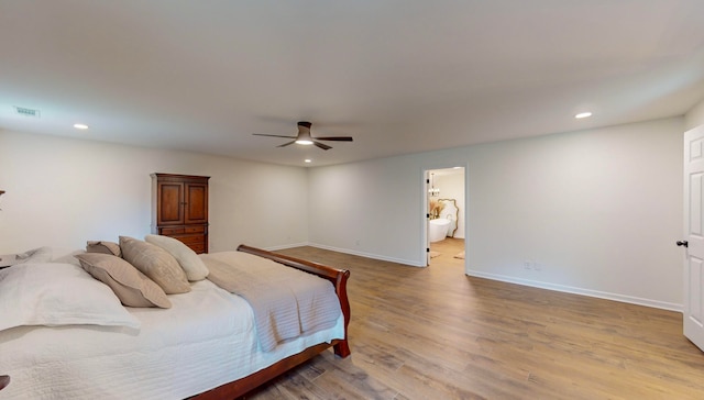 bedroom with ceiling fan, ensuite bathroom, and light wood-type flooring