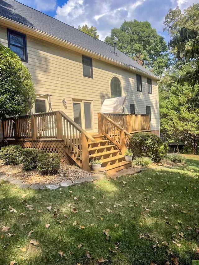 back of house with a deck and a yard