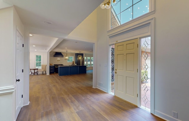 foyer with dark wood-type flooring and a chandelier