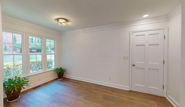 empty room featuring dark hardwood / wood-style flooring and crown molding