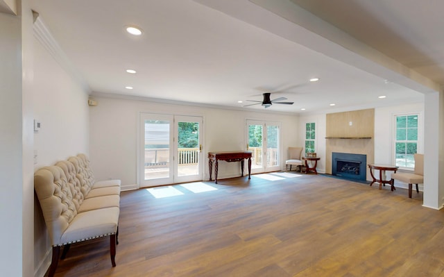 living room featuring ceiling fan, wood-type flooring, and ornamental molding