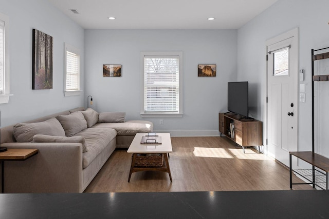 living room featuring recessed lighting, plenty of natural light, and light wood-style floors