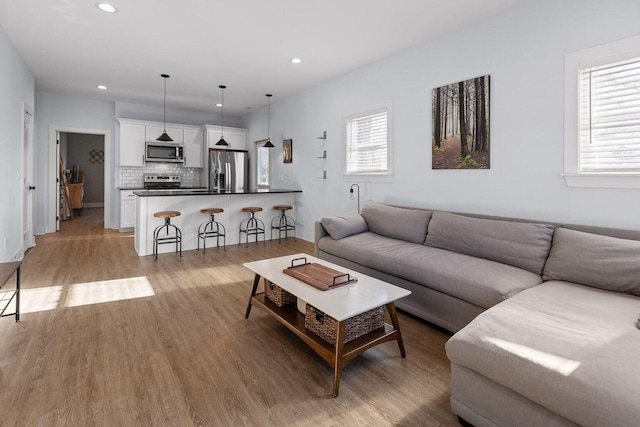 living area with light wood finished floors, plenty of natural light, and recessed lighting