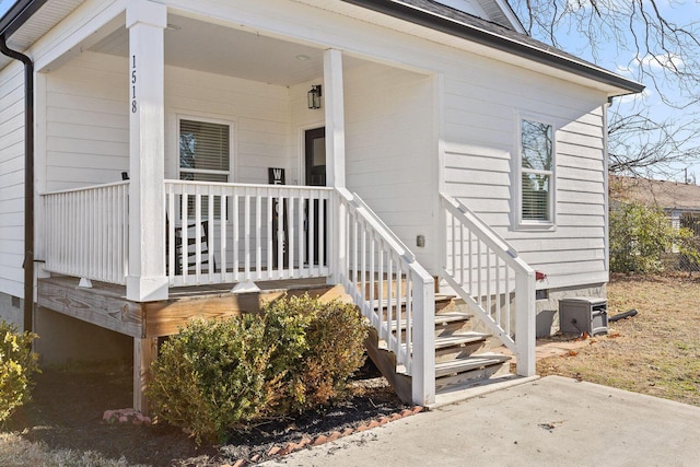 doorway to property with covered porch and central AC unit