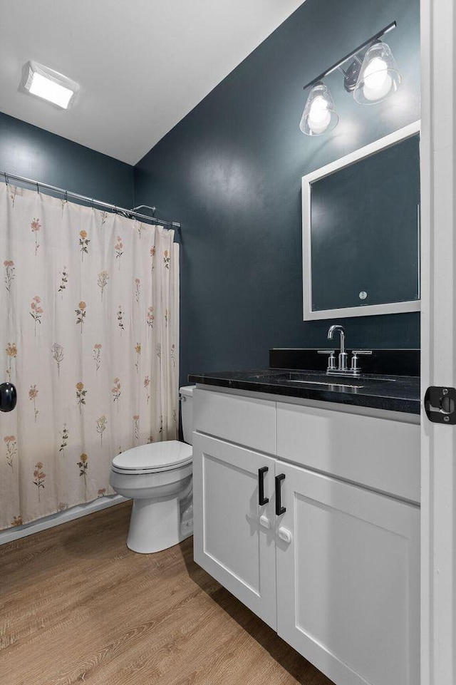 full bathroom featuring toilet, wood finished floors, and vanity