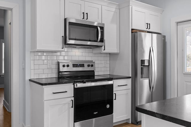 kitchen with dark countertops, white cabinets, and stainless steel appliances