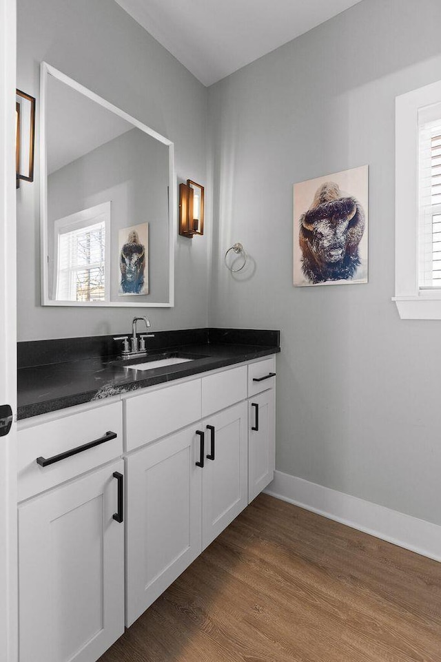 bathroom with a wealth of natural light, wood finished floors, vanity, and baseboards