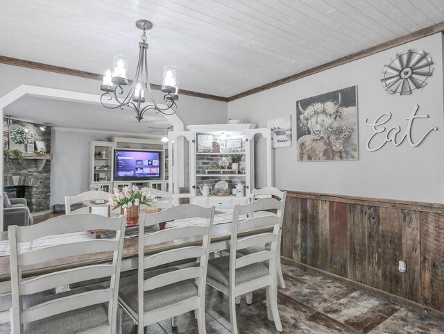 dining space featuring a wainscoted wall, an inviting chandelier, wood ceiling, french doors, and crown molding