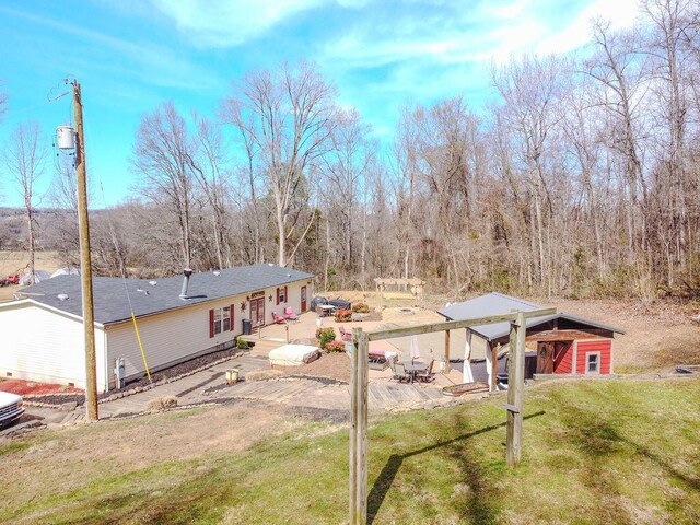 back of property featuring an outdoor structure, a yard, and a wooden deck