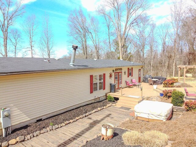 rear view of property featuring a wooden deck, french doors, and a pergola