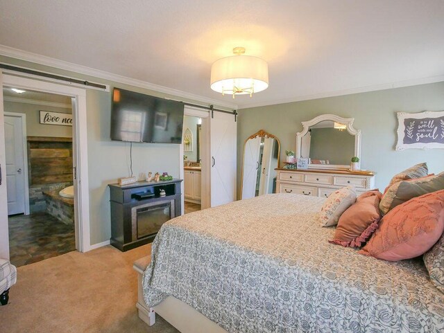 carpeted bedroom with a barn door, ensuite bathroom, and crown molding