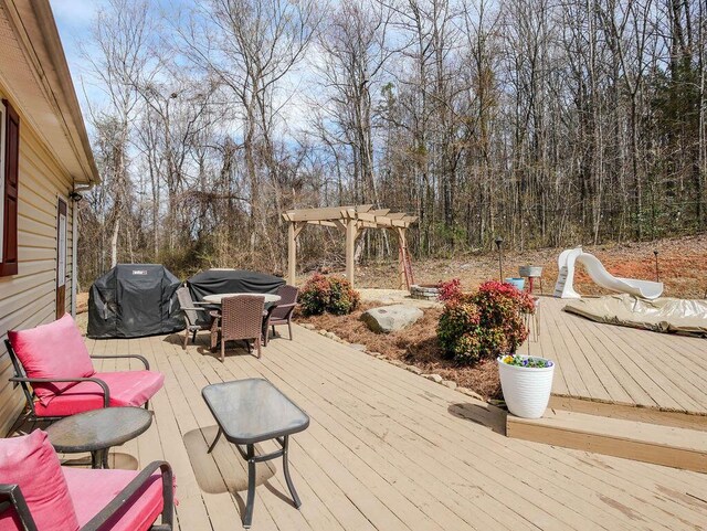 wooden terrace with a grill and a pergola