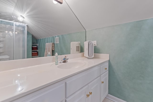 bathroom with vanity, a shower with shower door, and vaulted ceiling