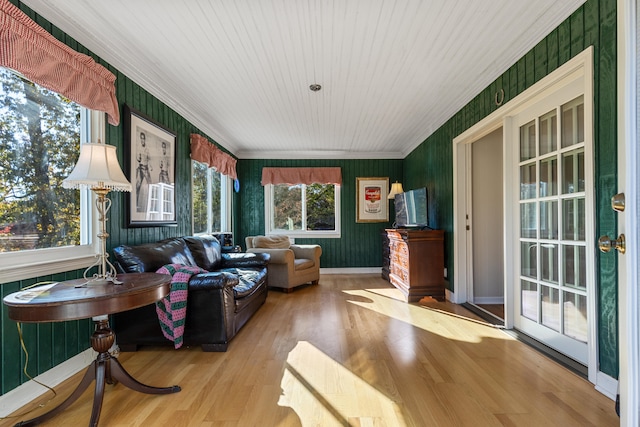 living room with crown molding, plenty of natural light, and light wood-type flooring