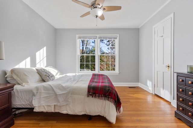 bedroom featuring ceiling fan, light wood-type flooring, and ornamental molding