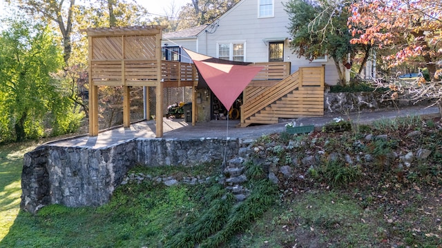 back of house featuring a wooden deck and a patio