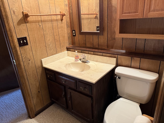 bathroom featuring wood walls, vanity, and toilet