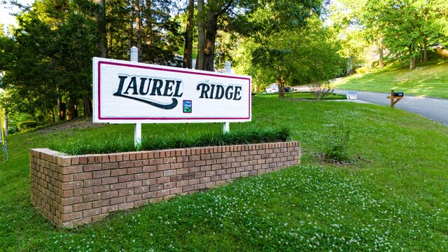 community / neighborhood sign featuring a lawn