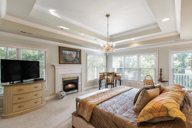 carpeted bedroom featuring a tray ceiling, an inviting chandelier, and crown molding