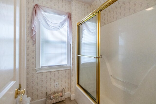 bathroom featuring bath / shower combo with glass door and a healthy amount of sunlight