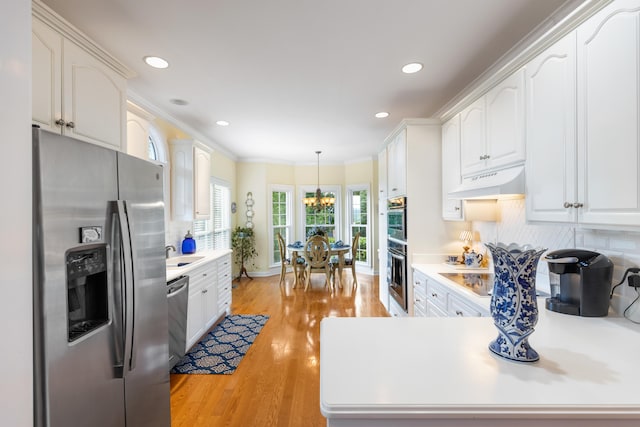 kitchen with white cabinetry, light hardwood / wood-style flooring, decorative light fixtures, custom range hood, and appliances with stainless steel finishes