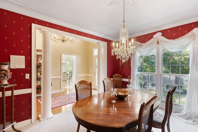 dining area featuring decorative columns, crown molding, hardwood / wood-style flooring, and a healthy amount of sunlight