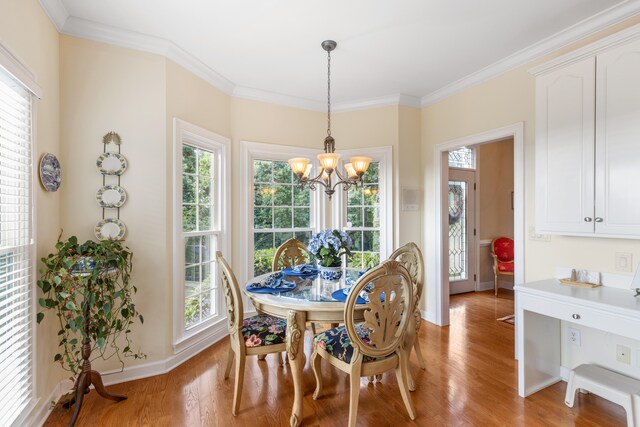 dining area featuring light wood-type flooring, ornamental molding, and a chandelier