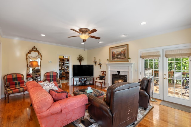 living room featuring crown molding, ceiling fan, and wood-type flooring