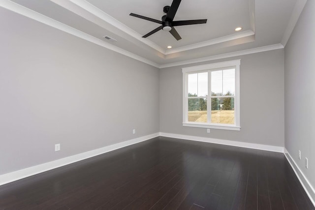 empty room with dark hardwood / wood-style floors, ornamental molding, a raised ceiling, and ceiling fan