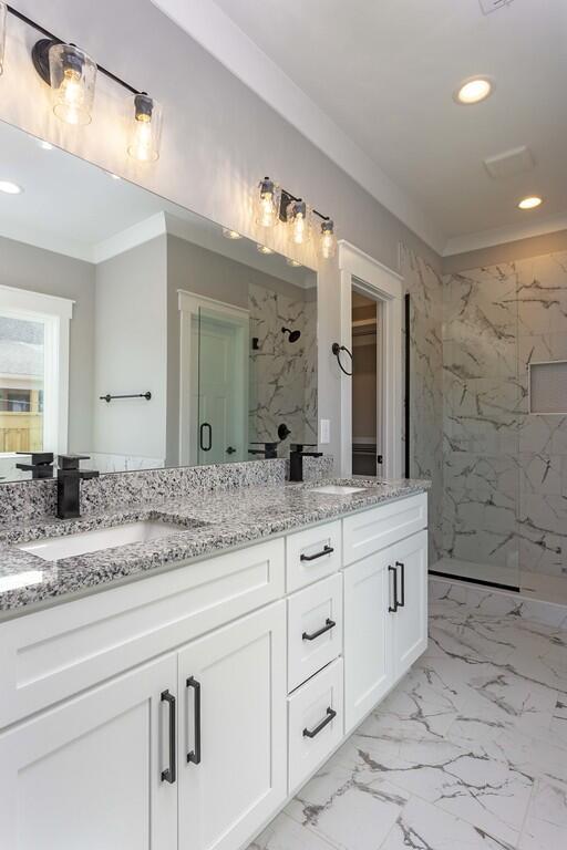 bathroom with vanity, tiled shower, and ornamental molding