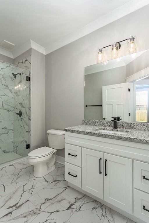 bathroom with toilet, vanity, a shower with door, and crown molding