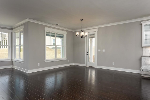 unfurnished room with dark hardwood / wood-style flooring, an inviting chandelier, and ornamental molding