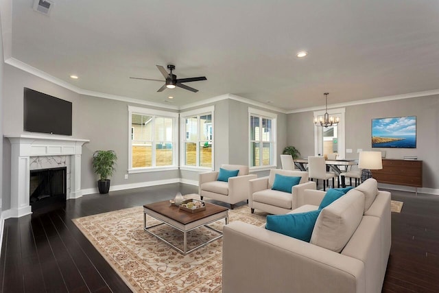 living room featuring ceiling fan with notable chandelier, ornamental molding, a fireplace, and dark hardwood / wood-style floors