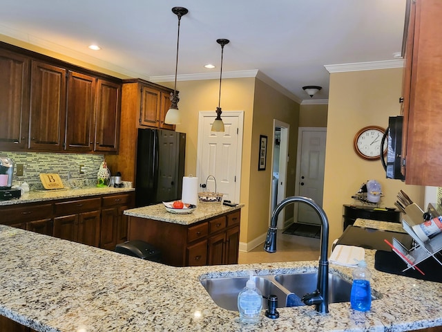 kitchen with sink, light stone counters, and black appliances