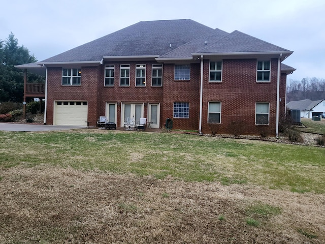 back of property with a garage and a yard