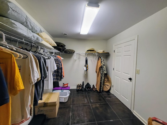 walk in closet with dark tile patterned flooring