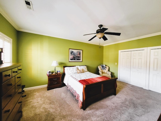 carpeted bedroom featuring multiple closets, ceiling fan, and ornamental molding