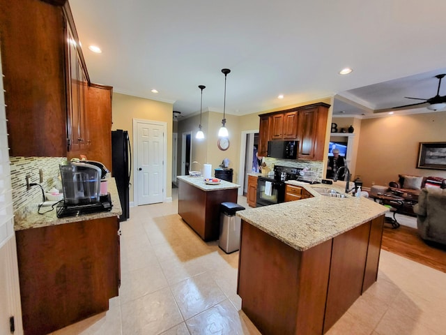 kitchen with sink, black appliances, an island with sink, decorative light fixtures, and kitchen peninsula