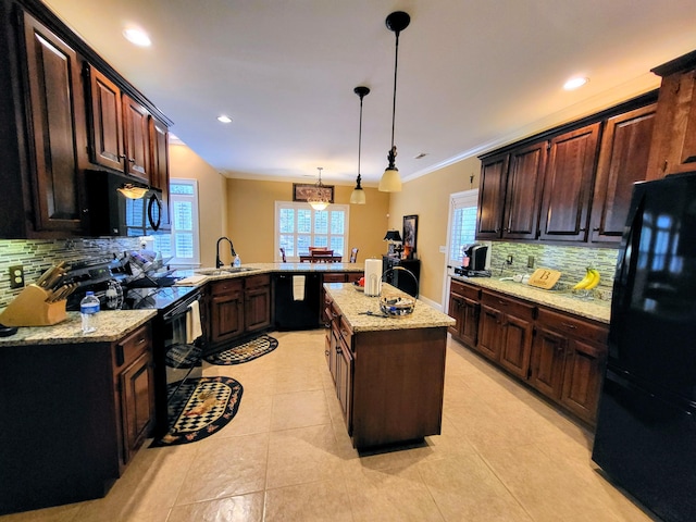 kitchen featuring pendant lighting, sink, a center island, black appliances, and kitchen peninsula