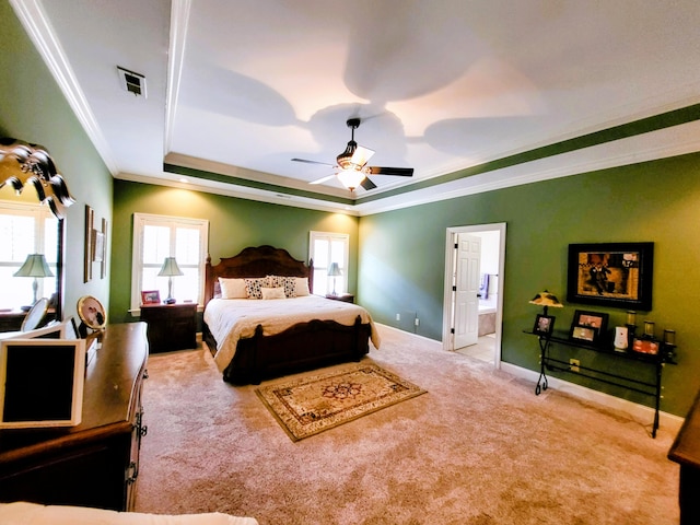 carpeted bedroom with ceiling fan, ornamental molding, connected bathroom, and a raised ceiling