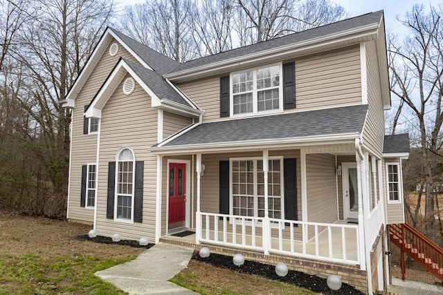 traditional home with a shingled roof and a porch